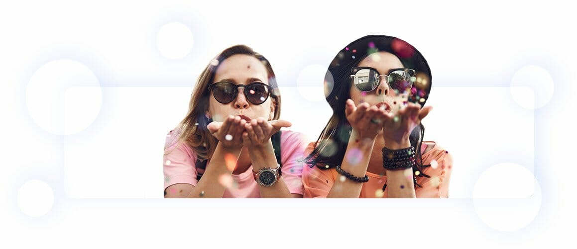 Two women wearing sunglasses blowing confetti out of their hands. Our Partners, Affiliate Marketing Team